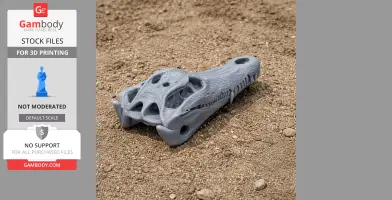 A detailed 3D-printed crocodile skull replica resting on sandy ground.