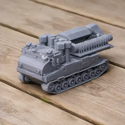 Gray 3D-printed futuristic tank model with detailed tracks and mounted equipment on a wooden surface.