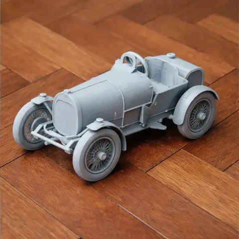 3D-printed model of a vintage Bugatti Type 13 car on a wooden floor.