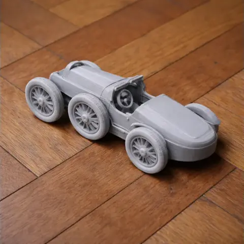 3D printed model of a classic Bugatti Type 35 car with detailed wheels on a wooden surface.