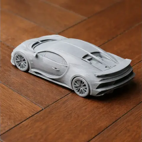 3D printed scale model of a Bugatti Veyron on a wooden surface.