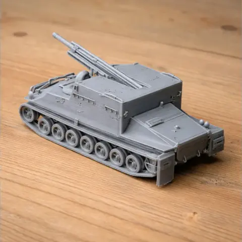 3D-printed model of a tank-like armoured personnel carrier with tracks on a wooden surface.