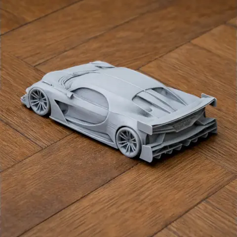 Gray 3D printed model of a Bugatti Vision Gran Turismo car on a wooden surface.