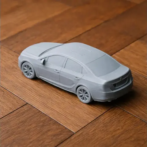 Gray 3D-printed model of a Buick car, displayed on a wooden surface.