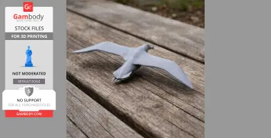 Gray 3D-printed model of a flying albatross on a wooden surface.