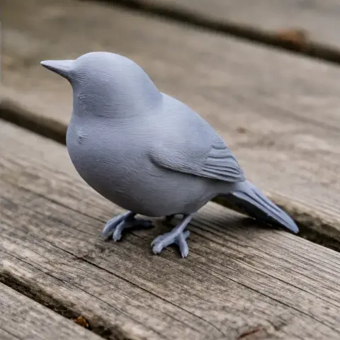 Gray 3D-printed model of a bird, standing on a wooden surface.