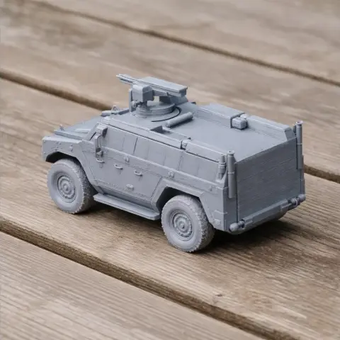 Gray 3D-printed model of a BOV M16 Milos tank on a wooden surface.