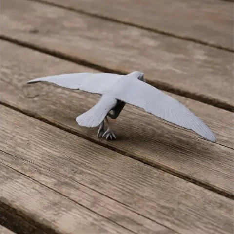 3D-printed Antarctic prion model with outstretched wings, displayed on a wooden surface.