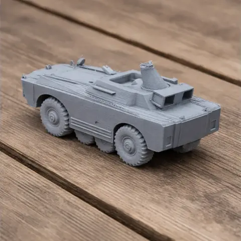 Gray 3D-printed model of a BRDM-1 armored vehicle, displayed on a wooden surface.