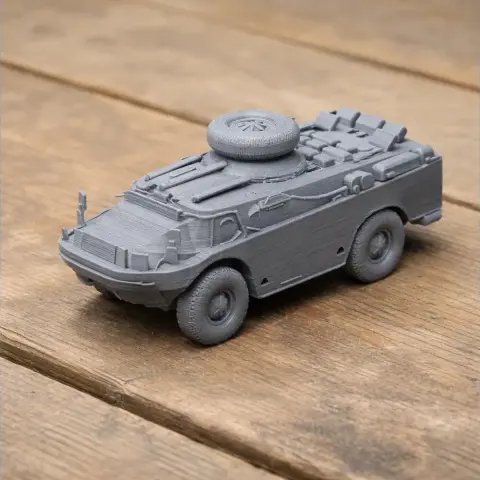 A detailed 3D-printed model of a BRDM-2 armored vehicle on a wooden surface.
