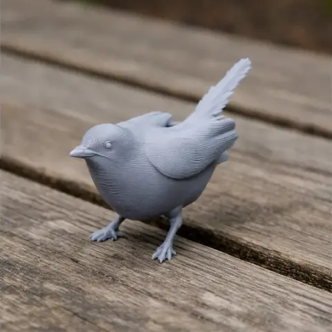 Gray 3D-printed model of an Arabian warbler bird on a wooden surface.
