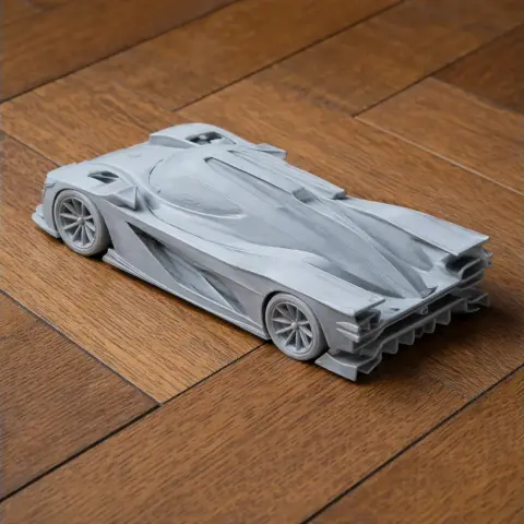 3D printed model of a sleek, futuristic race car on a wooden surface.