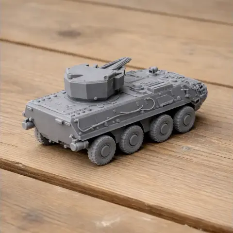 Gray 3D-printed BTR-4 armored vehicle model on a wooden surface.