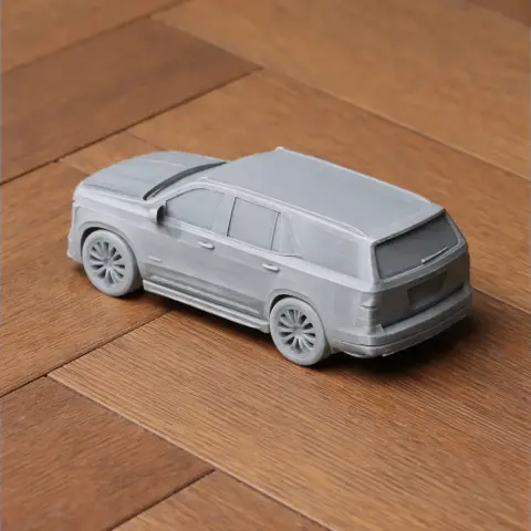 A 3D-printed model of a Cadillac Escalade on a wooden surface.