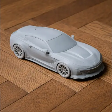 A detailed 3D printed model of a sleek, modern sports car on a wooden surface.