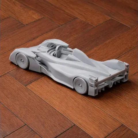 Detailed 3D printed Caparo T1 model car, placed on a wooden surface.