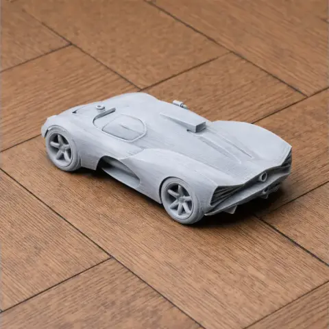 A detailed 3D printed model of a Chaparral 2D race car on a wooden surface.