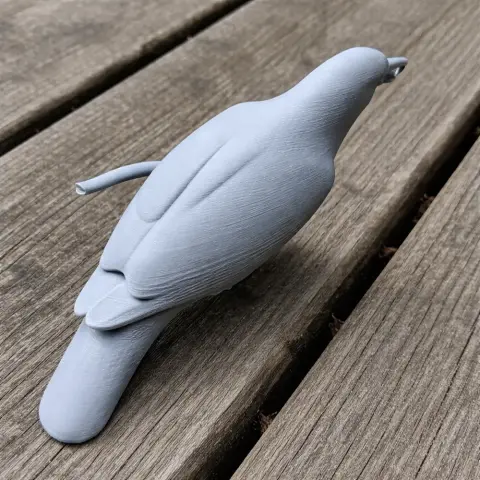 3D printed gray bird model resembling an Ashy myzomela, displayed on a wooden surface.