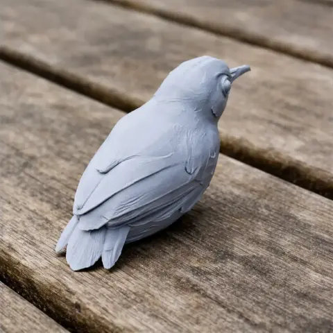 3D-printed gray Ashy-headed babbler bird model resting on a wooden surface.