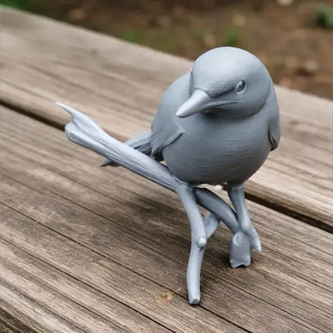 3D printed model of a bird perched on a branch, displayed on a wooden surface.