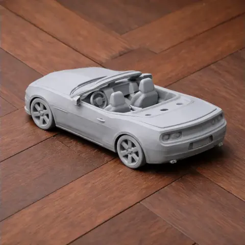 3D-printed model of a Chevrolet Camaro convertible on a wooden surface.