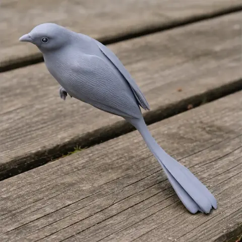 Gray 3D-printed model of a bird with a long tail, posed on a wooden surface.