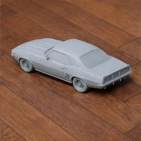 3D-printed 1969 Chevrolet Camaro model on wooden surface, viewed from rear side.