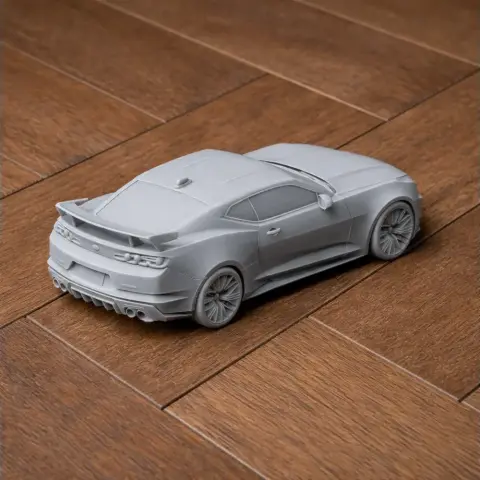 Scale model of a Chevrolet Camaro ZL1 in gray, displayed on a wooden surface.