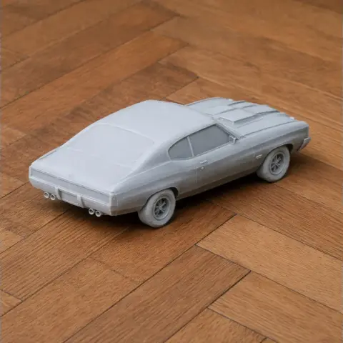 3D printed model of a classic Chevrolet Chevelle car on a wooden surface.