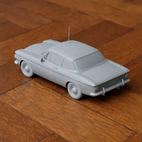 Gray 3D printed model of a Chevrolet Corvair, shown on a wooden surface.