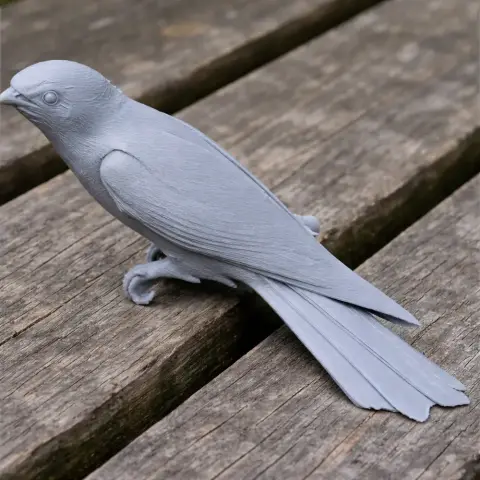 3D-printed model of an Asian emerald cuckoo on a wooden surface.