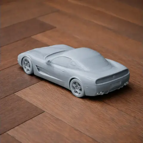 A 3D printed model of a Chevrolet Corvette C5-R on a wooden surface.