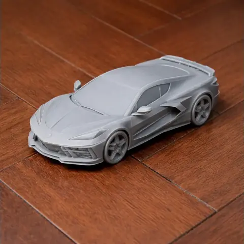 3D printed model of a Chevrolet Corvette C8 on a wooden surface.