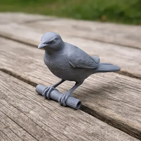 3D-printed model of a bird perched on a small branch, displayed on a wooden surface.
