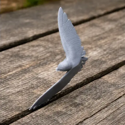 3D printed model of an Asian palm swift in flight on a wooden surface.