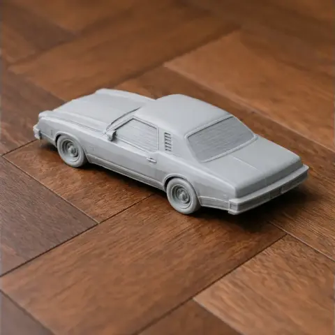 A gray 3D printed model of a Chevrolet Chevelle Laguna on a wooden surface.