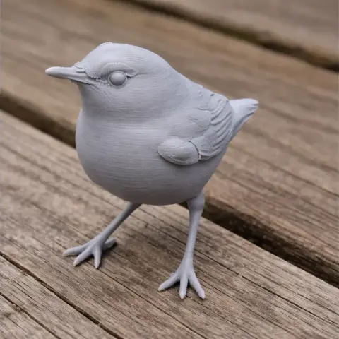 3D printed model of a bird, resembling a stubtail, standing on a wooden surface.