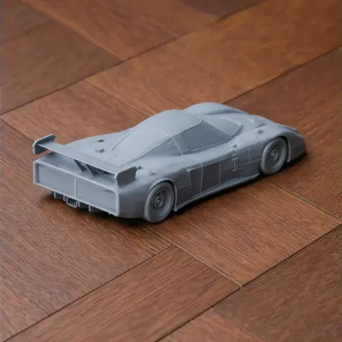 Gray 3D-printed model of a Chevrolet Corvette GTP race car on a wooden surface.