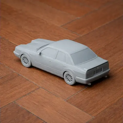 A gray 3D-printed model of a Chevrolet Monza car on a wooden surface.
