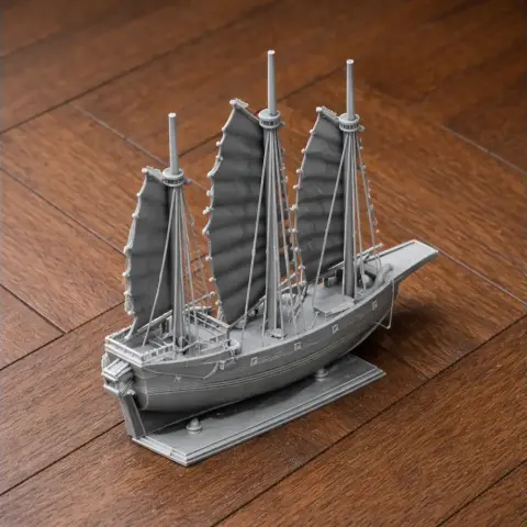3D printed model of a traditional Chinese junk ship with three sails on a wooden surface.