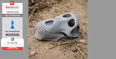 3D printed olive baboon skull replica resting on sandy ground with scattered twigs.