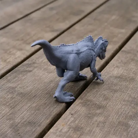Gray 3D-printed model of an Acrocanthosaurus dinosaur on a wooden surface.