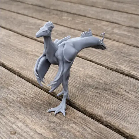 A gray 3D-printed model of Afromimus, a theropod dinosaur, posed standing on a wooden surface.