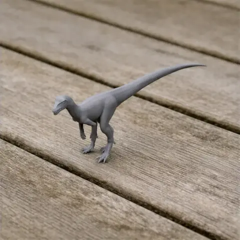 A gray 3D-printed prehistoric dinosaur model stands on a wooden surface.