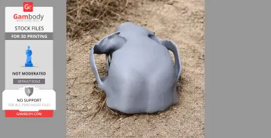 A 3D-printed otter shrew skull replica placed on sandy ground.