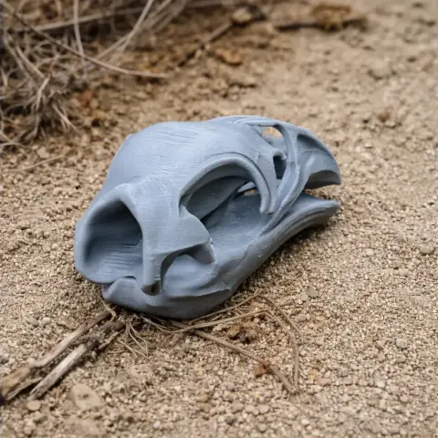 3D-printed Pachyornis elephantopus skull replica resting on sandy ground.