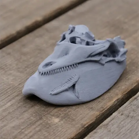A 3D-printed prehistoric animal skull with sharp teeth, displayed on a wooden surface.