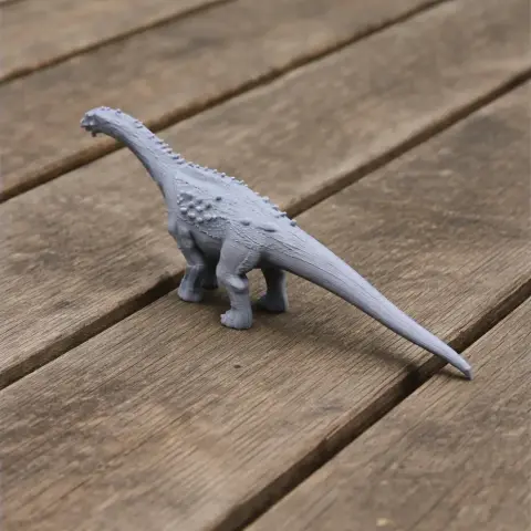A 3D printed model of an Ampelosaurus dinosaur on a wooden surface.