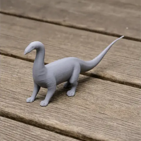 3D printed model of a long-necked, tailed dinosaur on a wooden surface.
