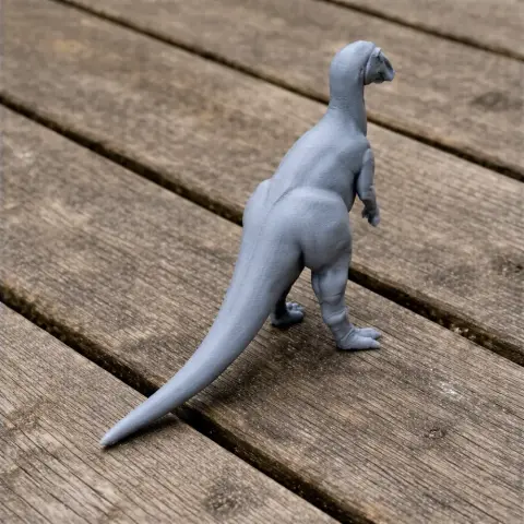 3D printed Anatosaurus model in gray, standing on a wooden surface.